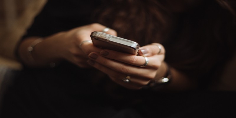 A close-up of a woman’s hands using a smartphone. A close-up of a woman’s hands using a smartphone.