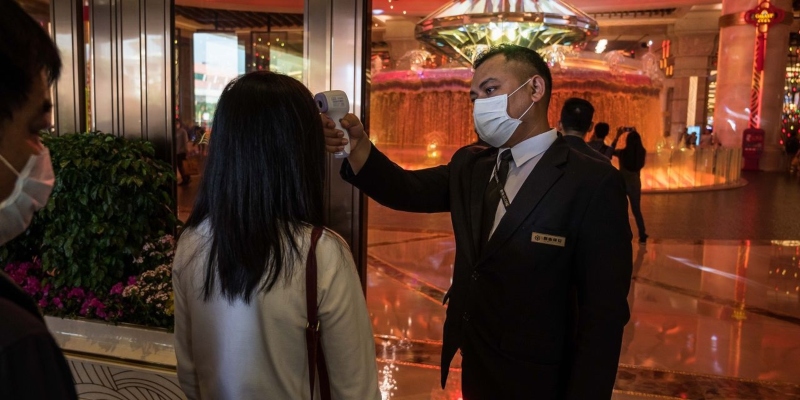 Gente con 'cubrebocas' afuera del Casino Lisboa, en Macao
