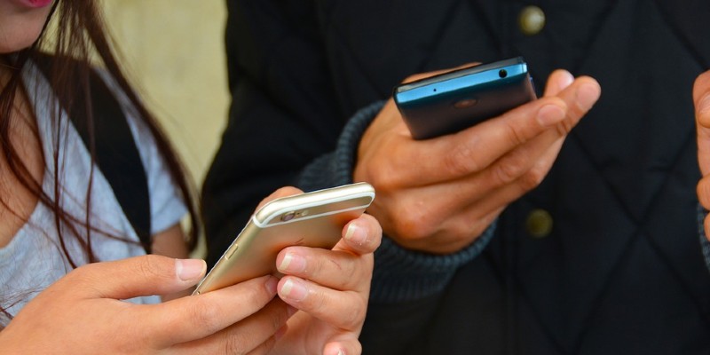 Two people holding smartphones Two people holding smartphones