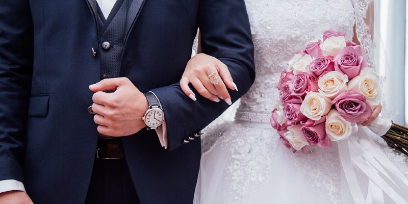 Bride and groom arm in arm with bouquet Bride and groom arm in arm with bouquet